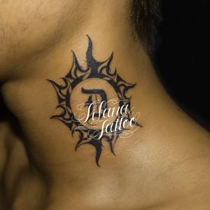太陽とイニシャルのタトゥー